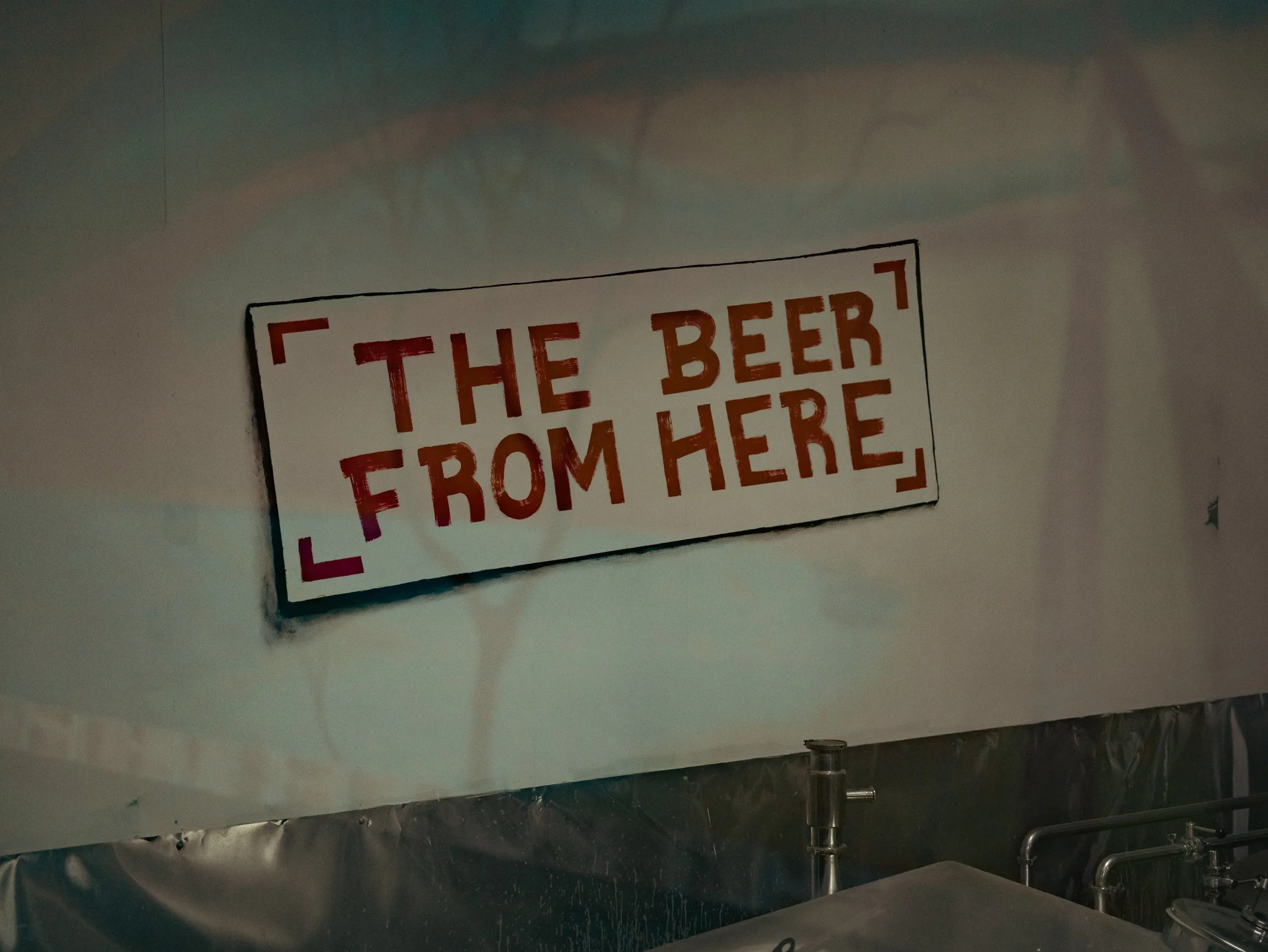 Hand-painted sign on the brewery wall reading The beer from here