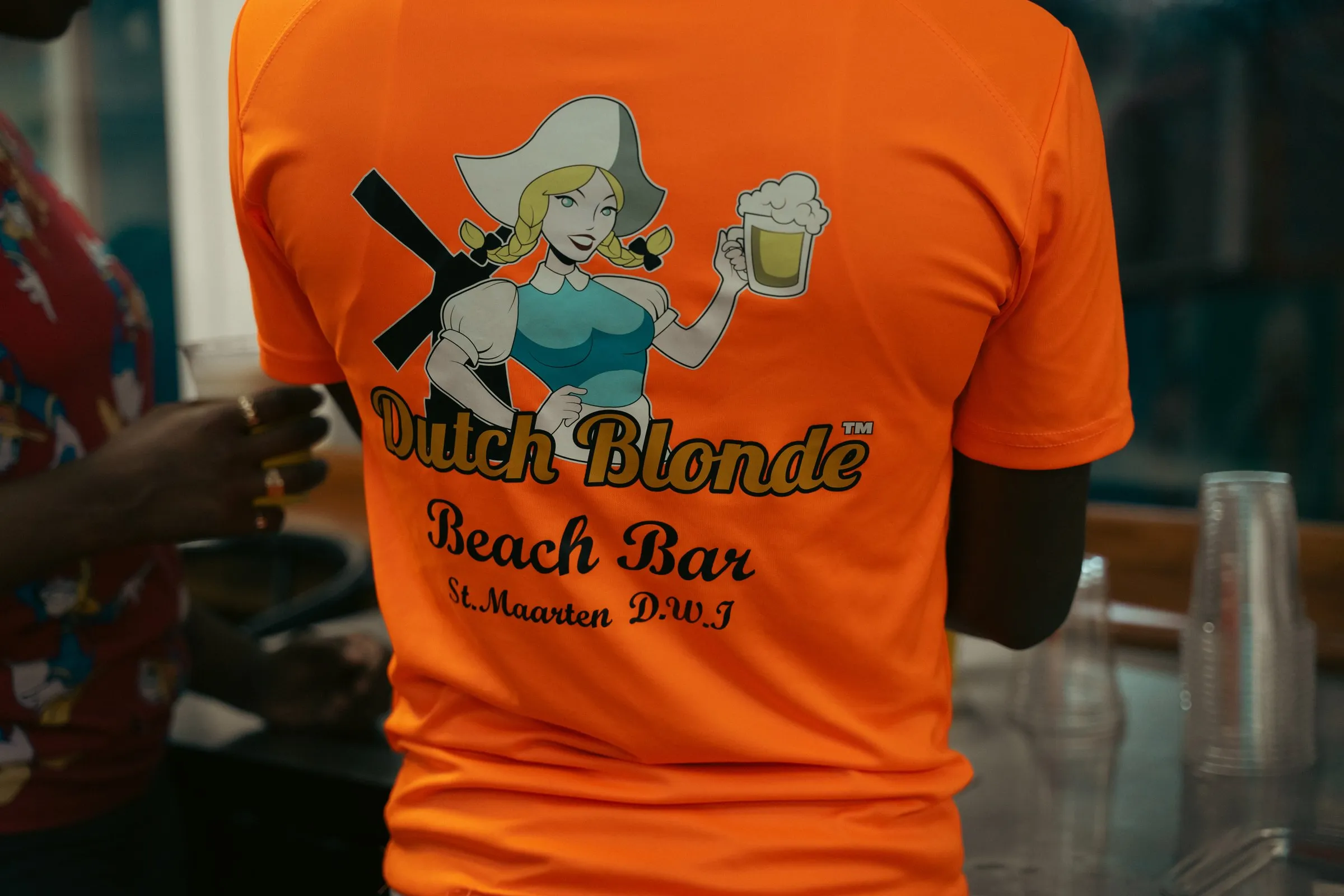 Staff member in an orange Dutch Blonde Beach Bar shirt