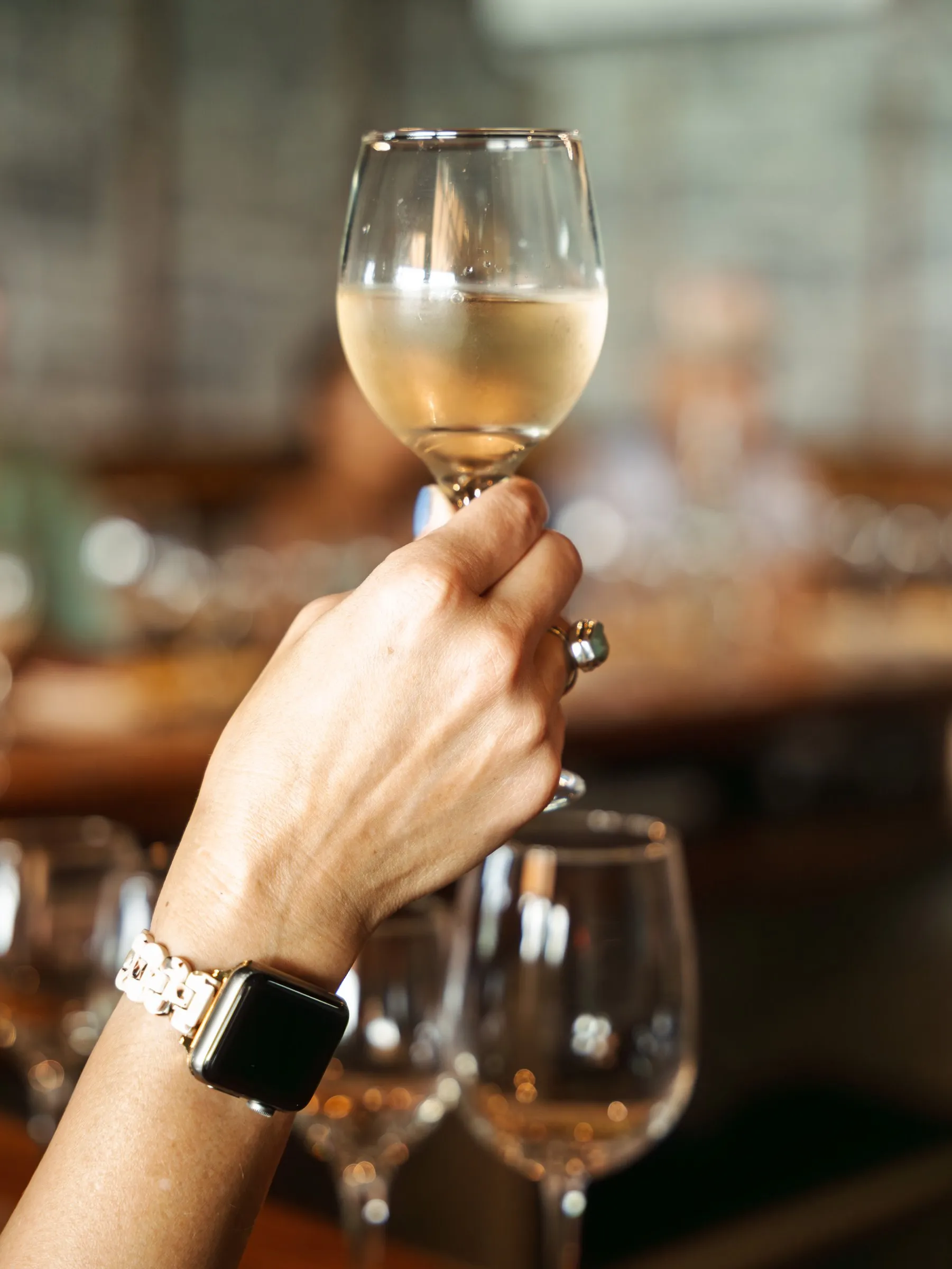 A guest holds up a glass of white wine