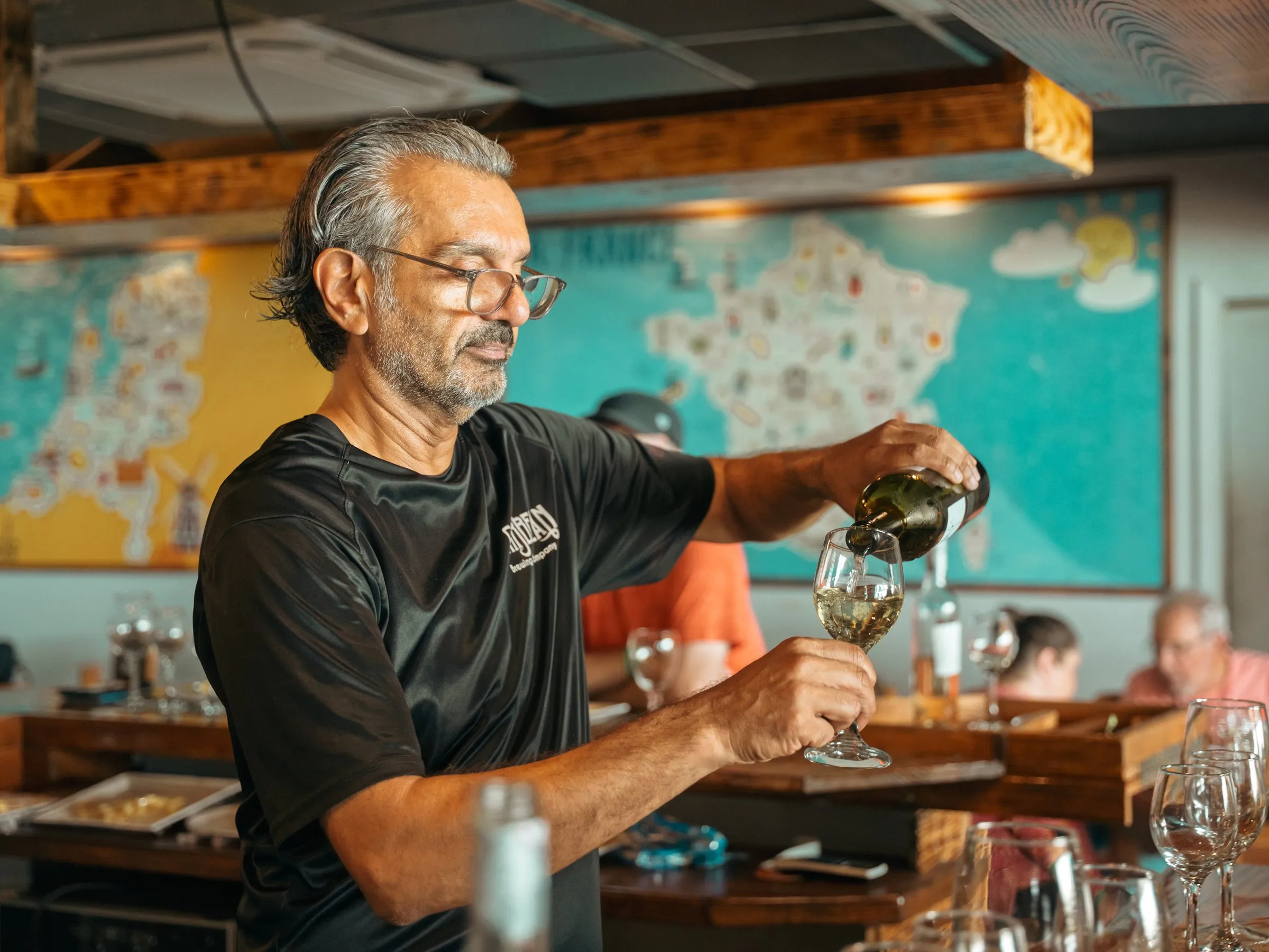 The host pours wine for guests at the tasting